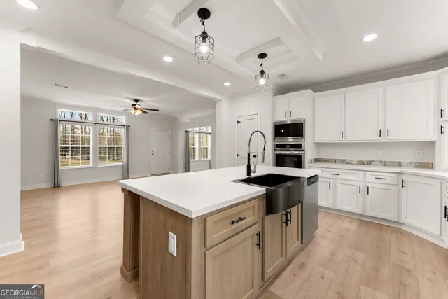 a kitchen that has a lot of cabinets in it and wooden floors