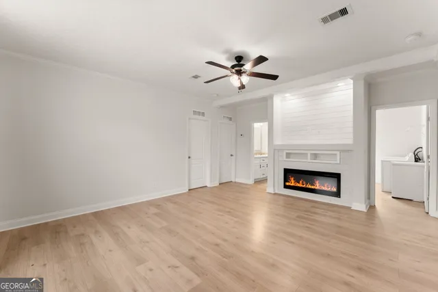 a view of an empty room with a fireplace and a window