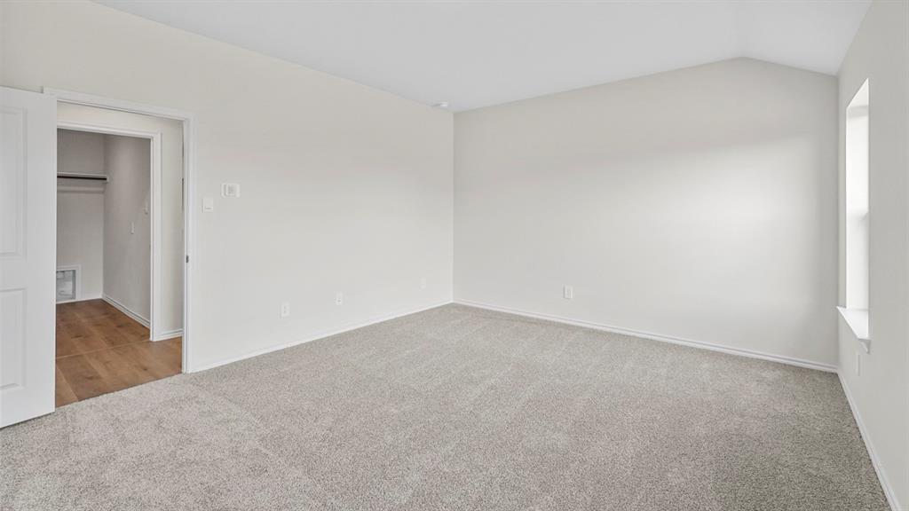 1953 Freeman Street Tyler, TX 75704 - Photo 17 of 32 Spacious room featuring light-colored carpeting, a vaulted ceiling, and a large window