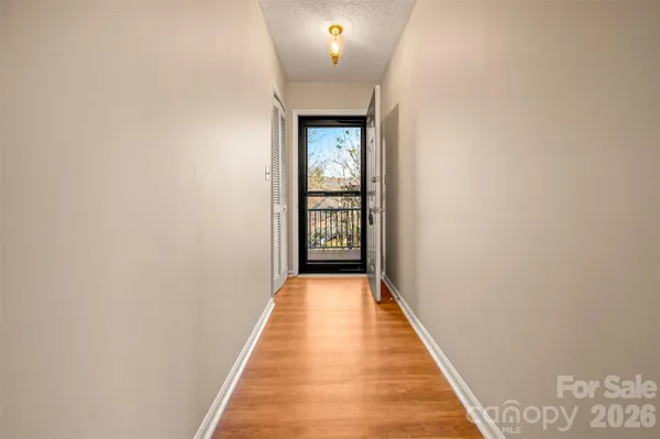a view of empty room with wooden floor and fan