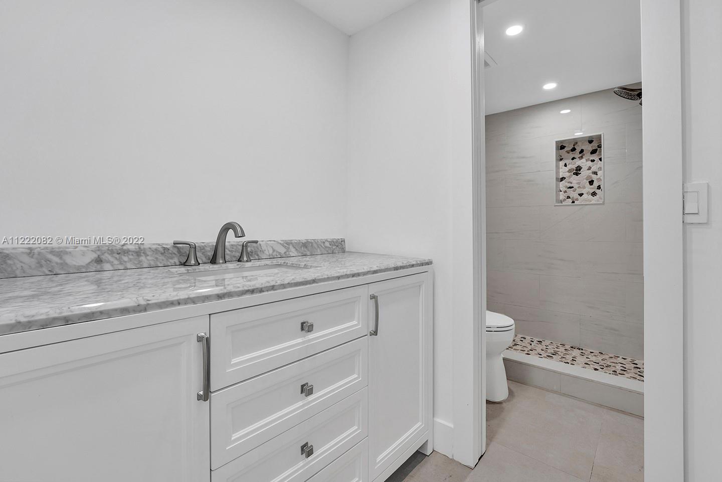 6904 North Kendall Drive, Unit F102 Pinecrest, FL 33156 - Photo 11 of 19 a bathroom with a granite countertop toilet and a sink