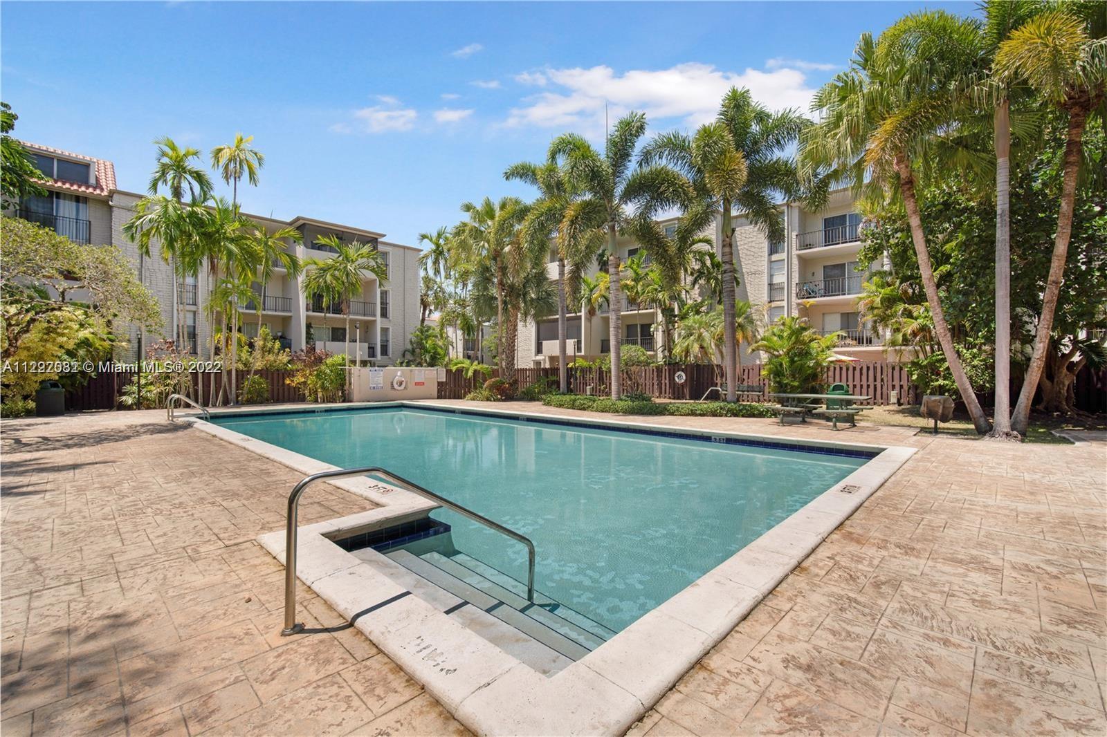 6904 North Kendall Drive, Unit F102 Pinecrest, FL 33156 - Photo 17 of 19 a view of a swimming pool with a patio