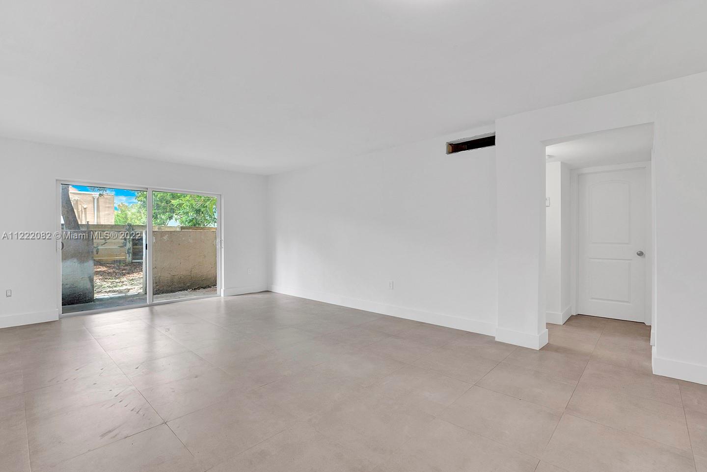 6904 North Kendall Drive, Unit F102 Pinecrest, FL 33156 - Photo 4 of 19 an empty room with wooden floor and windows