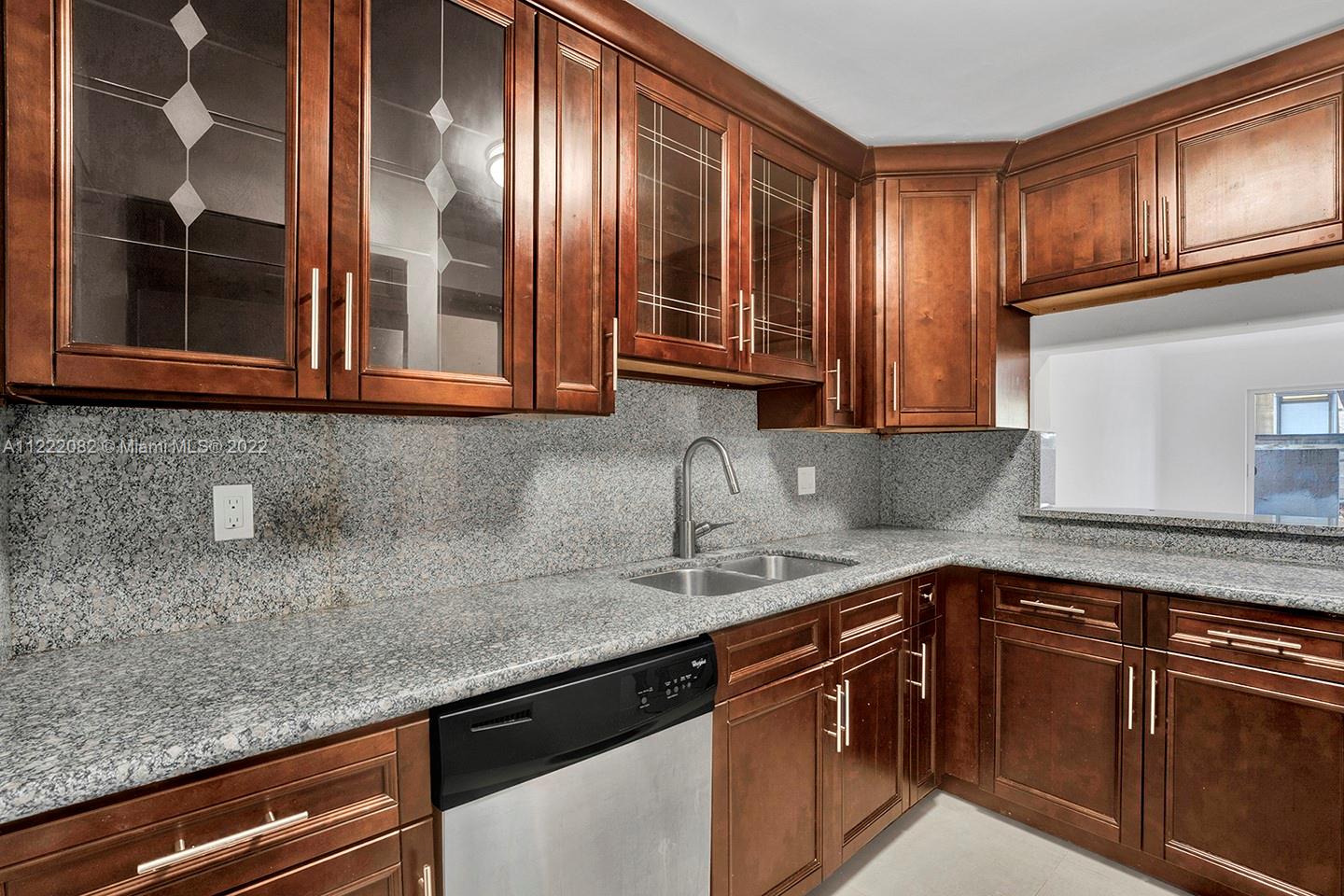 6904 North Kendall Drive, Unit F102 Pinecrest, FL 33156 - Photo 6 of 19 a kitchen with stainless steel appliances granite countertop a sink and cabinets