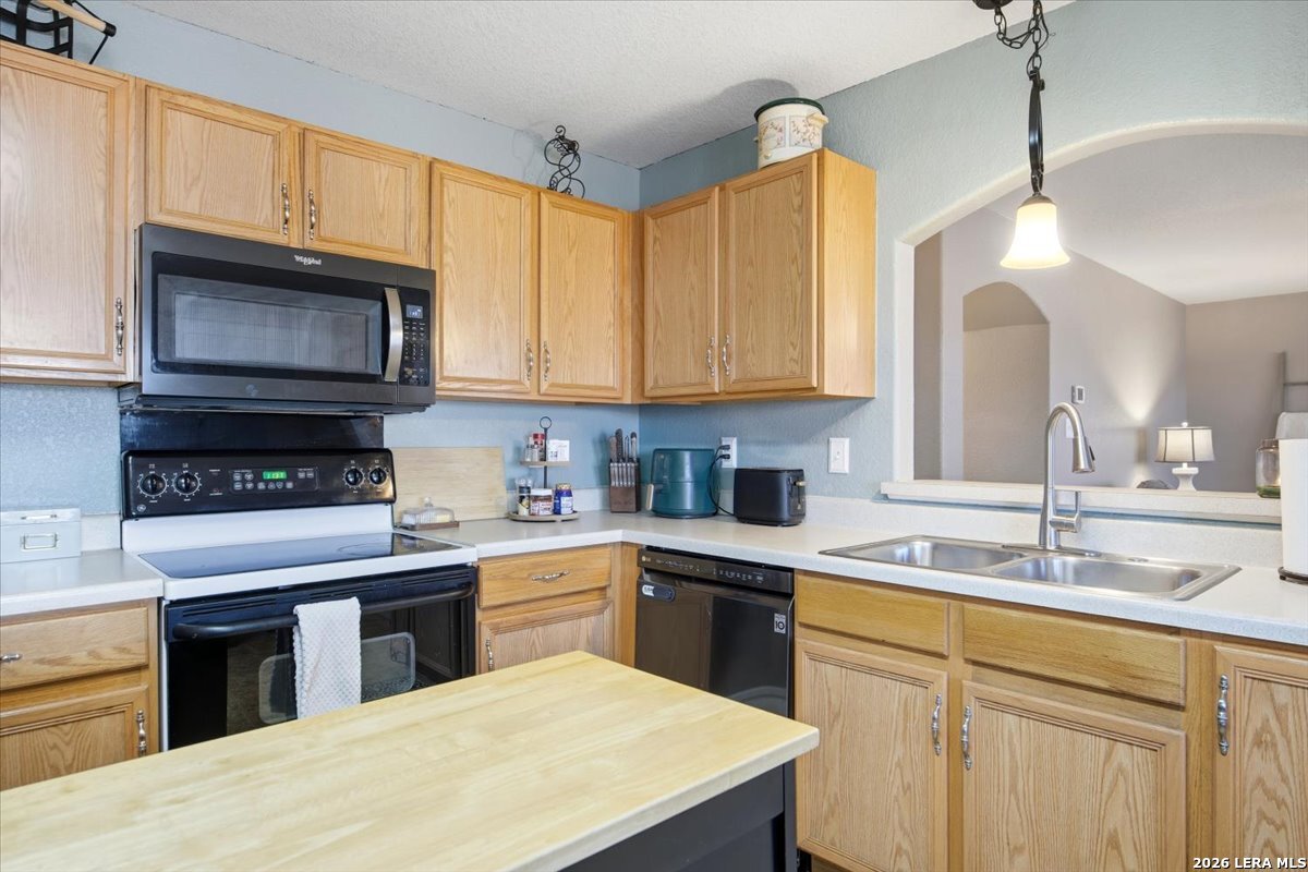 7311 Autumn Ledge Converse, TX 78109 - Photo 11 of 25 a kitchen with stainless steel appliances granite countertop a sink a stove a microwave and wooden cabinets