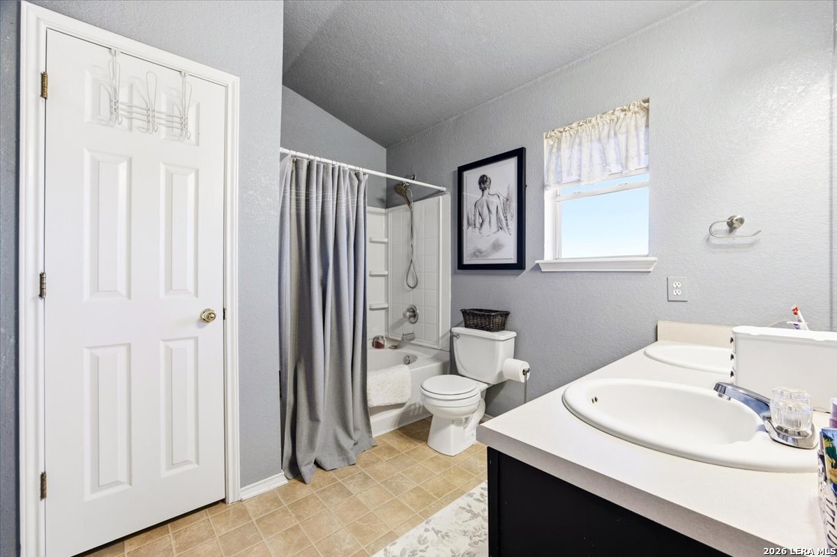 7311 Autumn Ledge Converse, TX 78109 - Photo 16 of 25 a bathroom with a sink a toilet and shower curtain