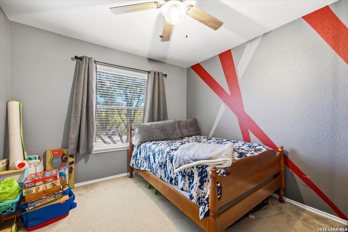 7311 Autumn Ledge Converse, TX 78109 - Photo 17 of 25 a bedroom with a bed and a chandelier