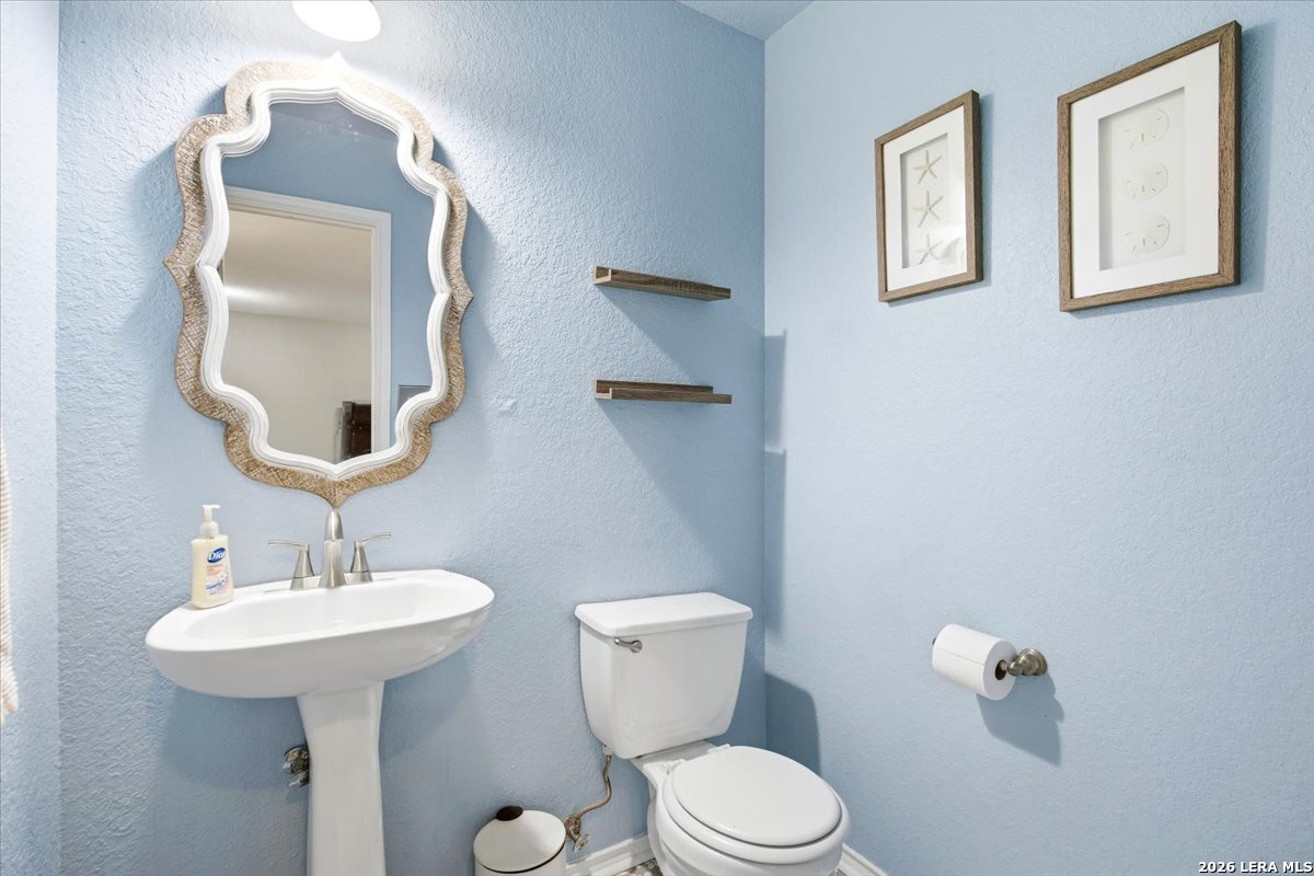 7311 Autumn Ledge Converse, TX 78109 - Photo 22 of 25 a bathroom with a toilet a sink and mirror