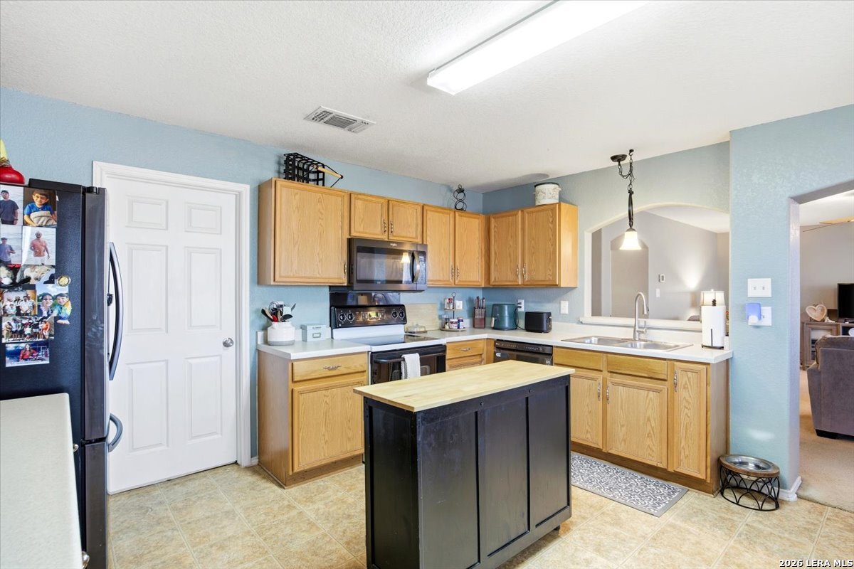 7311 Autumn Ledge Converse, TX 78109 - Photo 9 of 25 a kitchen with a stove a sink a refrigerator and cabinets