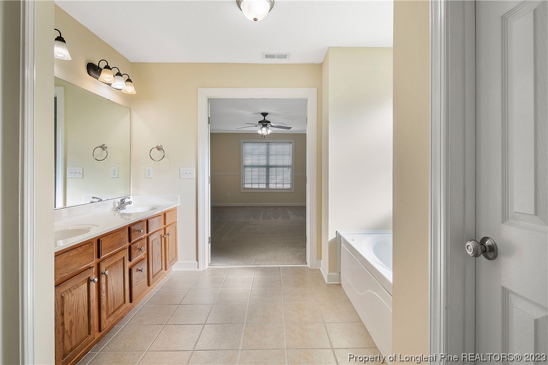 136 Linden Road Cameron, NC 28326 - Photo 31 of 48 a spacious bathroom with a double vanity sink a large mirror and a bathtub