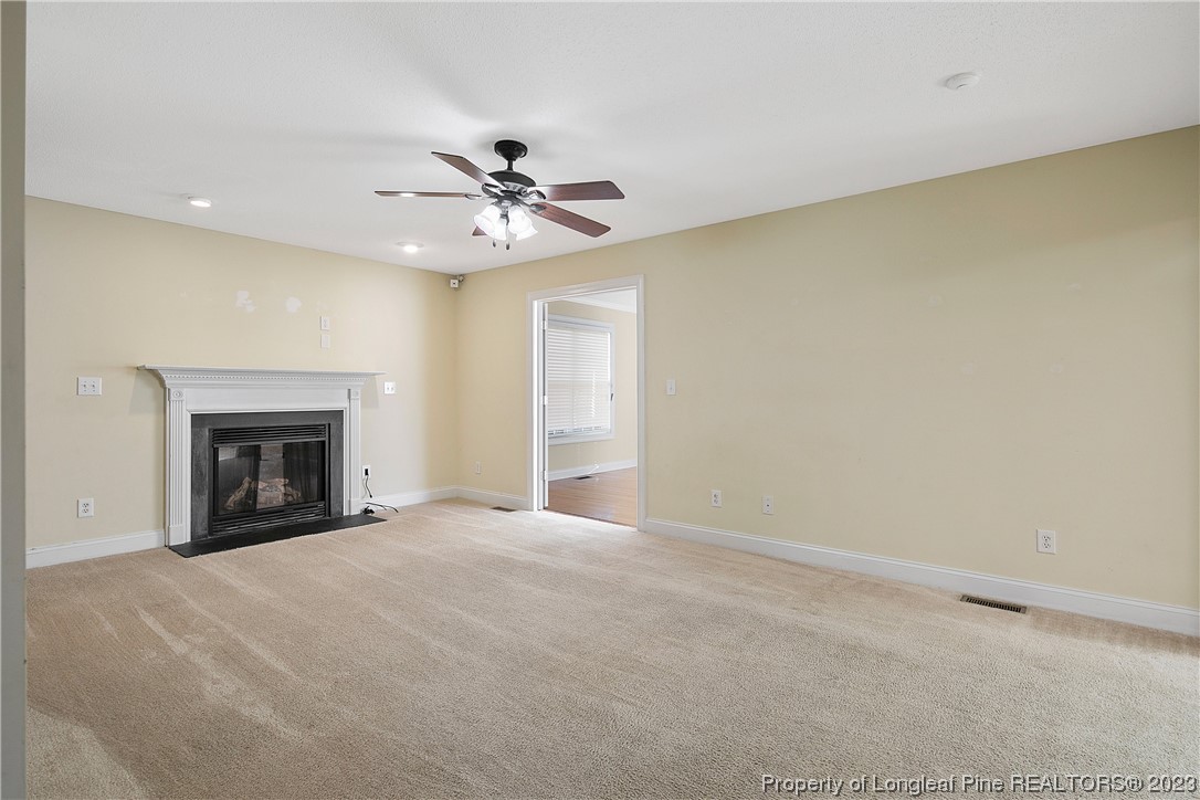 136 Linden Road Cameron, NC 28326 - Photo 9 of 48 a view of an empty room with a fireplace and a window