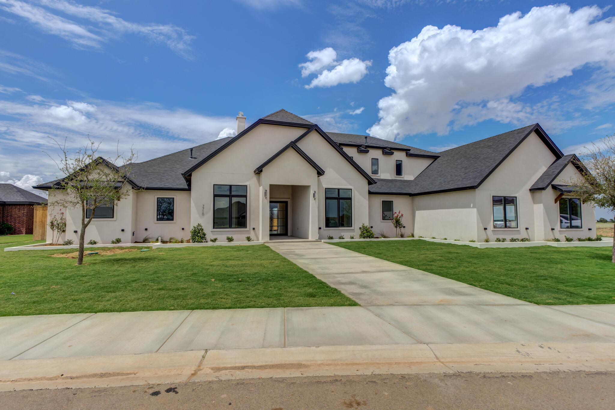7710 46th Street Lubbock, TX 79407 - Photo 11 of 79 a front view of a house with a garden and trees