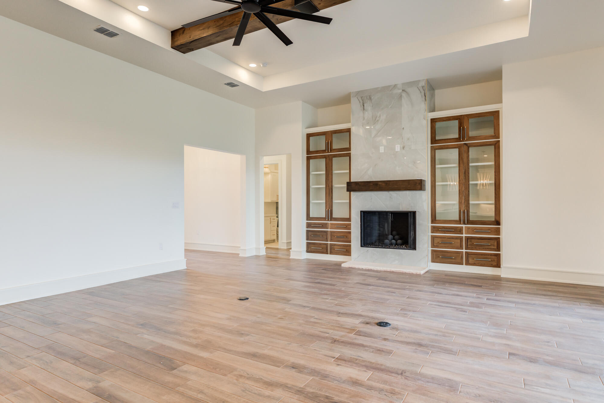 7710 46th Street Lubbock, TX 79407 - Photo 18 of 79 a view of an empty room with wooden floor fireplace and a window
