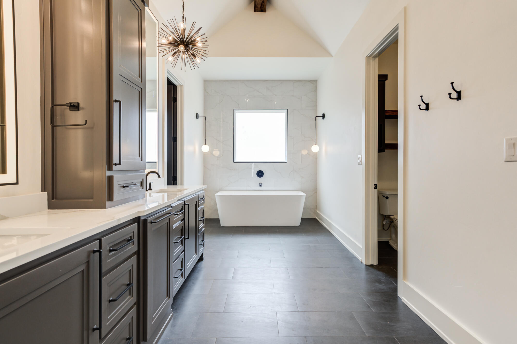 7710 46th Street Lubbock, TX 79407 - Photo 39 of 79 a bathroom with a double vanity sink a mirror and a bathtub