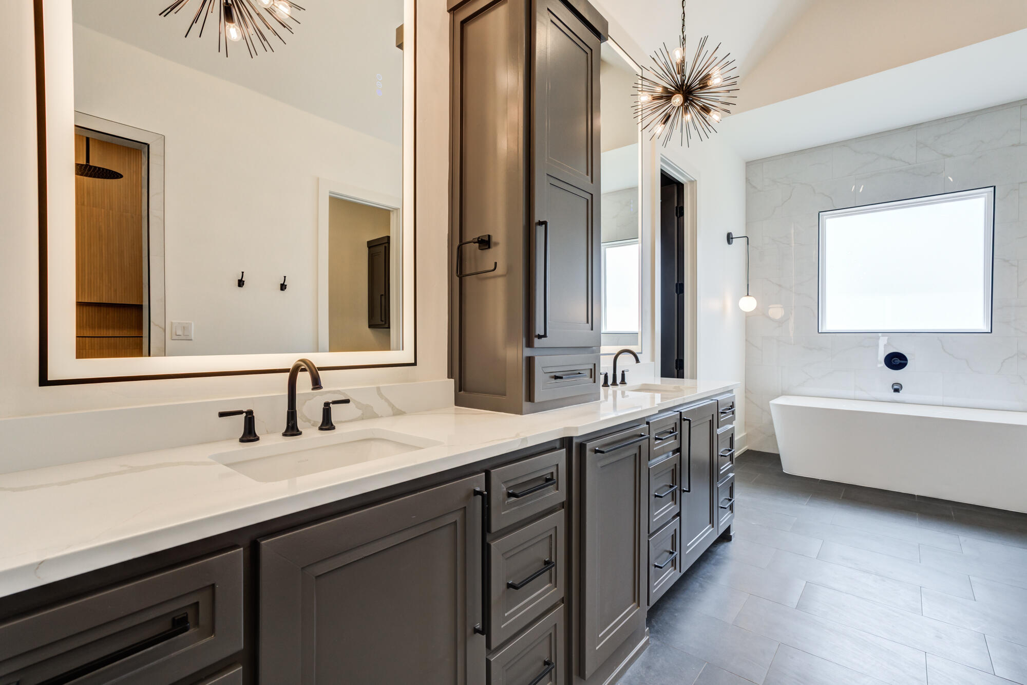 7710 46th Street Lubbock, TX 79407 - Photo 40 of 79 a bathroom with a double vanity sink a large mirror and a bathtub
