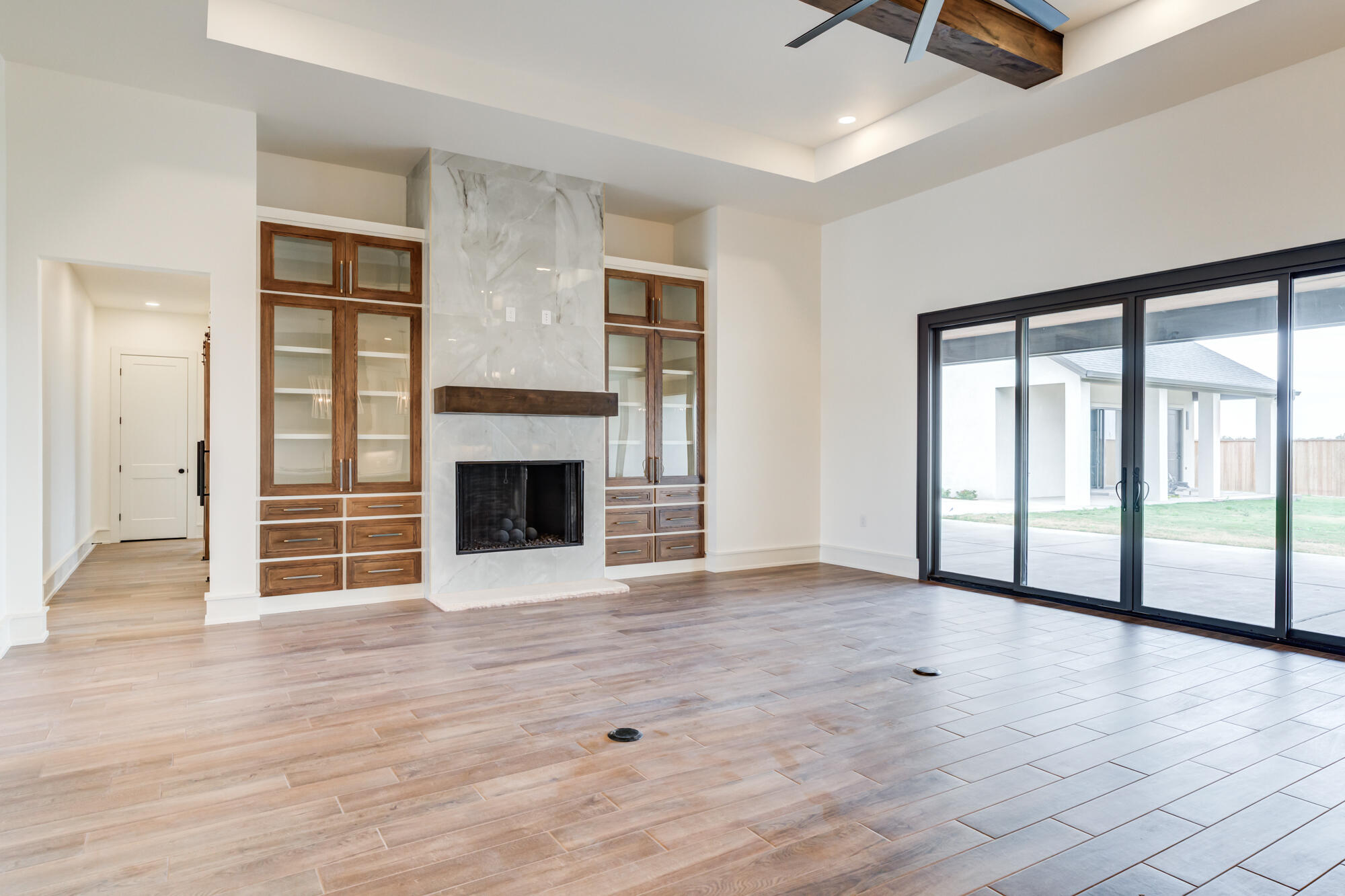 7710 46th Street Lubbock, TX 79407 - Photo 5 of 79 an empty room with wooden floor fireplace and windows
