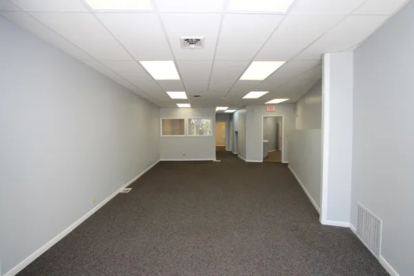 an empty room with a windows and ceiling fan