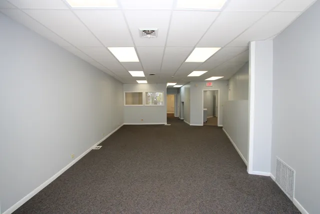 an empty room with a windows and ceiling fan