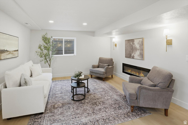 8760 Rustler Road Cottonwood Heights, UT 84093 - Photo 31 of 57 Spacious living area featuring light wood-finish flooring, recessed lighting, and an elongated electric fireplace