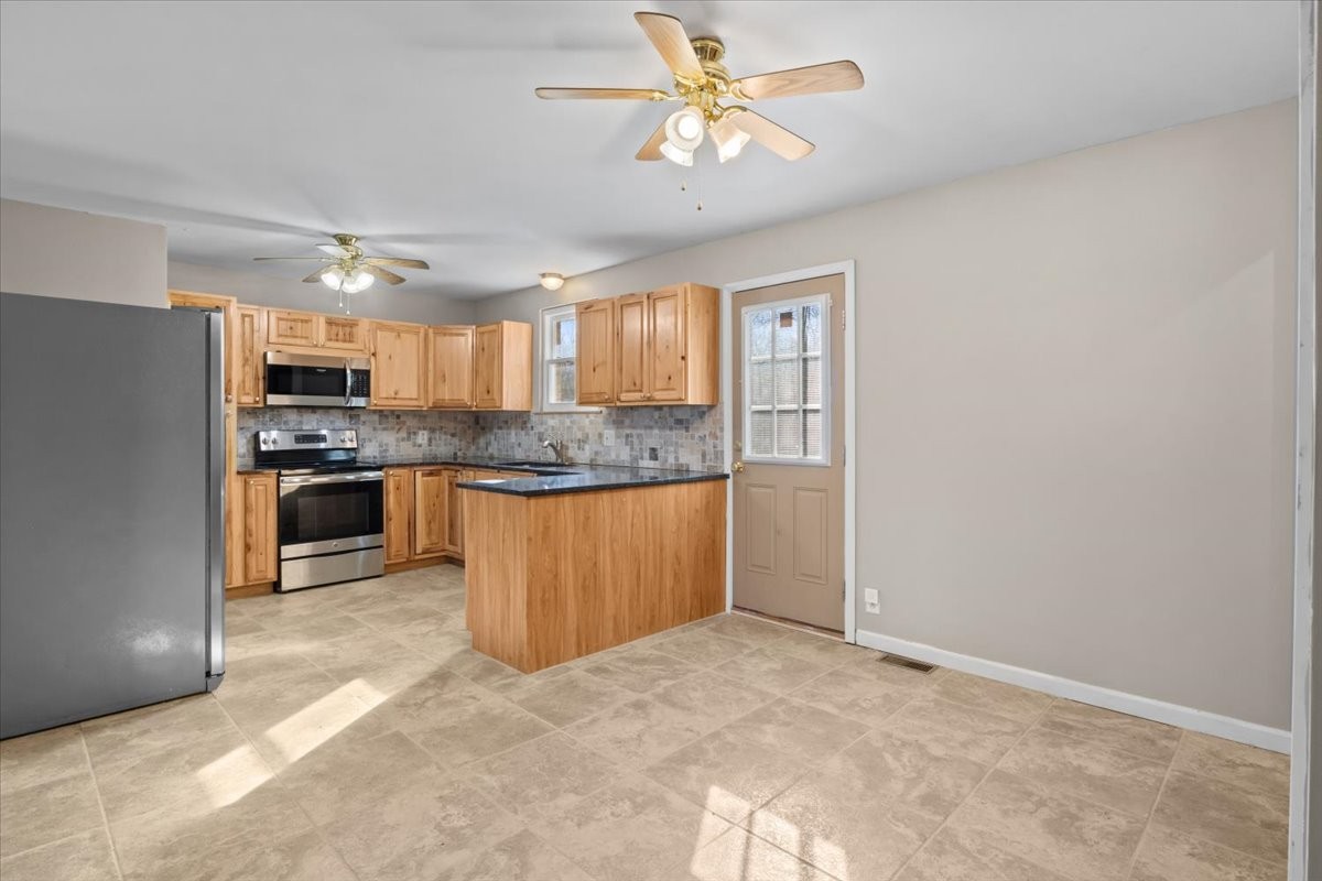 105 Mae Circle Dickson, TN 37055 - Photo 5 of 26 a kitchen with stainless steel appliances granite countertop a stove a sink and a refrigerator