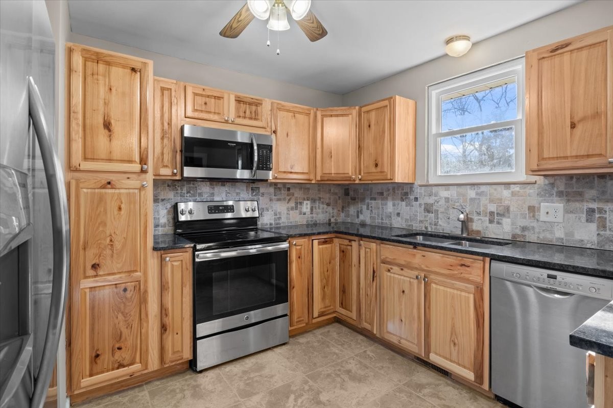105 Mae Circle Dickson, TN 37055 - Photo 7 of 26 a kitchen with stainless steel appliances granite countertop a stove sink microwave and refrigerator