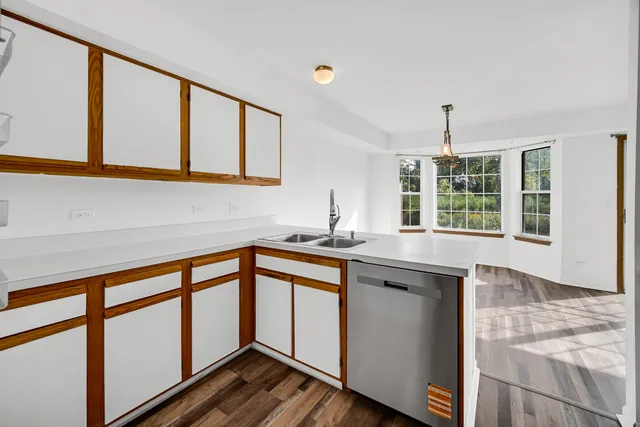 a kitchen with stainless steel appliances granite countertop a sink and wooden cabinets