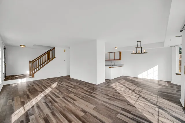 a view of a bedroom with wooden floor and kitchen