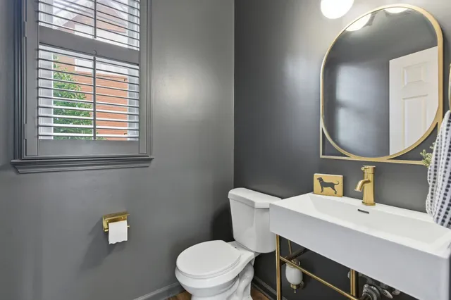 a bathroom with a toilet sink vanity and mirror