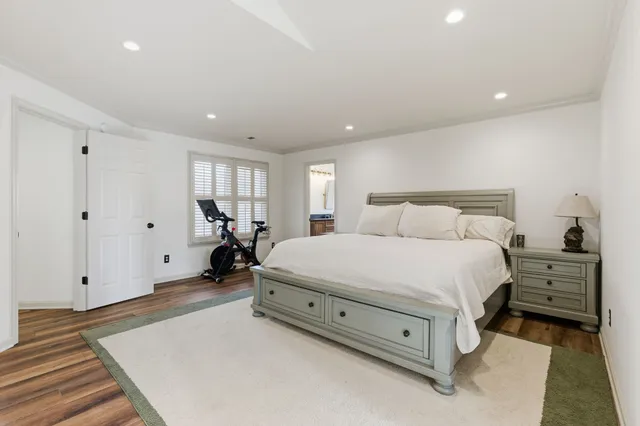 a spacious bedroom with a bed and a dresser