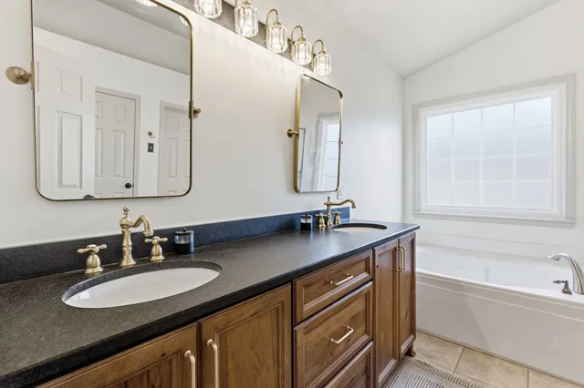 a bathroom with double vanity sinks and a mirror