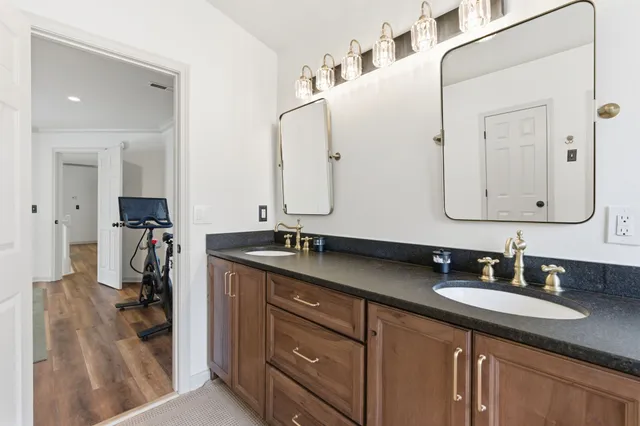 a bathroom with a granite countertop sink double vanity and a mirror