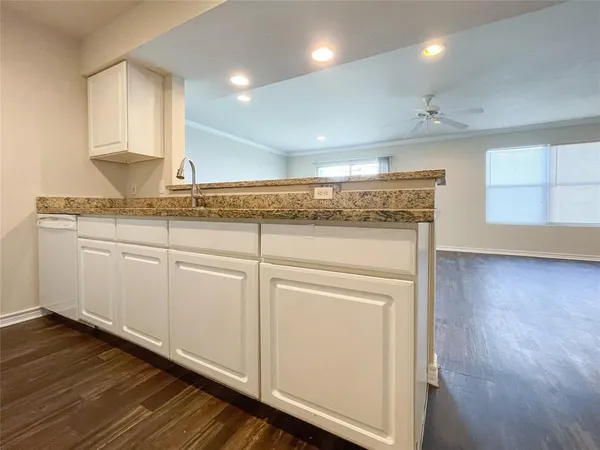 a kitchen with granite countertop white cabinets and white appliances