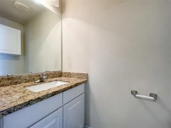 a bathroom with a granite countertop sink mirror and vanity