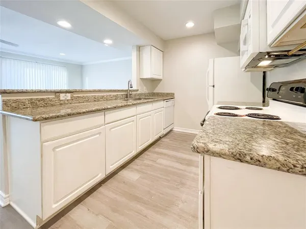 a kitchen with stainless steel appliances granite countertop a sink and a stove