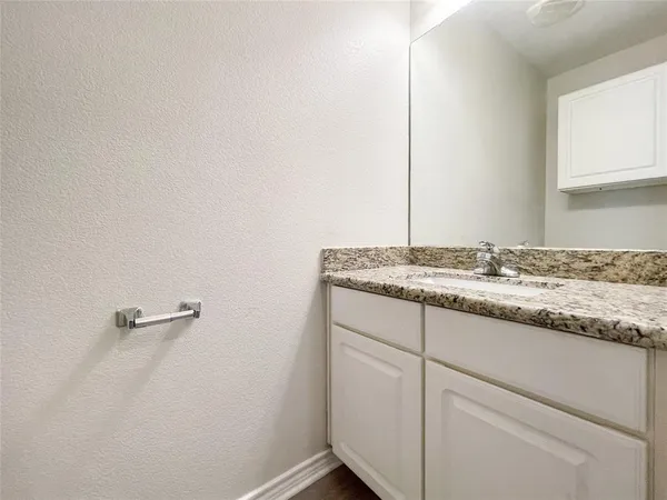 a bathroom with a granite countertop sink and vanity