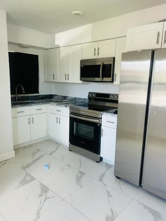 a kitchen with stainless steel appliances a stove a microwave and a sink