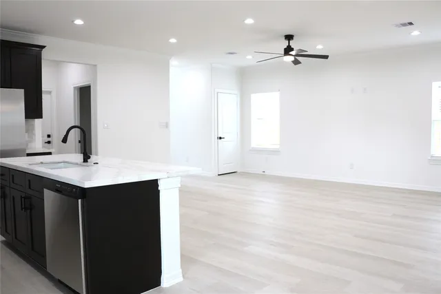 a kitchen with a sink cabinets and wooden floor