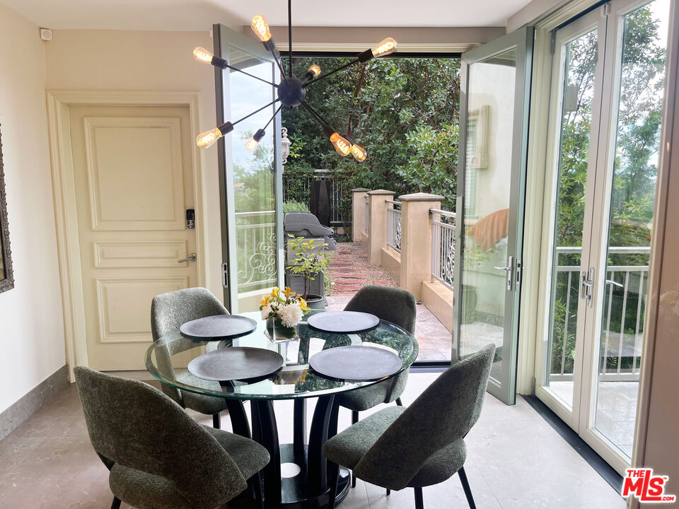 1861 Bel Air Road Los Angeles, CA 90077 - Photo 19 of 44 a dining room with furniture large windows and wooden floor