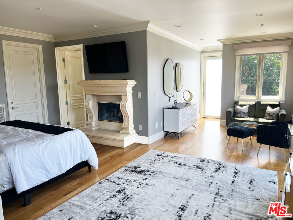 1861 Bel Air Road Los Angeles, CA 90077 - Photo 28 of 44 a living room with a bed a flat screen tv and a fireplace