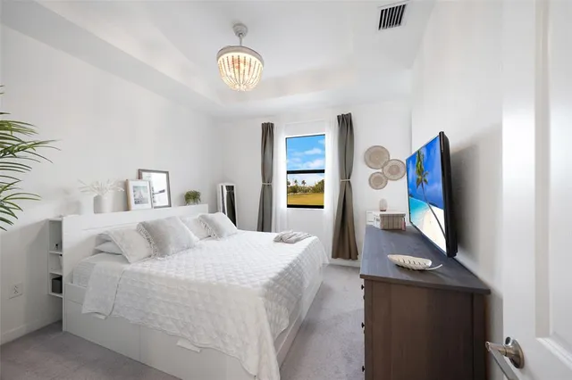 a bedroom with a bed and a lamp on dresser