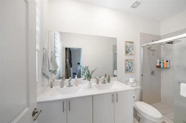a bathroom with a sink toilet a mirror and shower