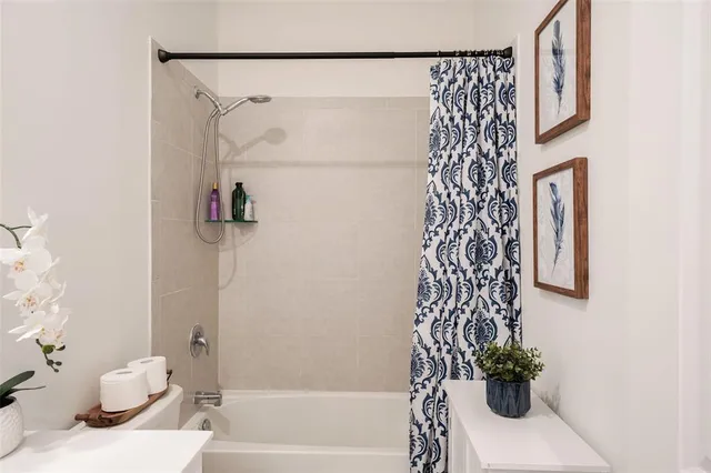 a bath room with a toilet and a shower curtain