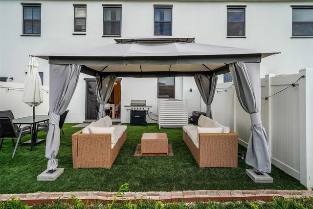 a view of a couches in the patio and a fountain in the back yard