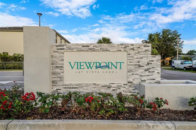 a sign board with buildings in the background