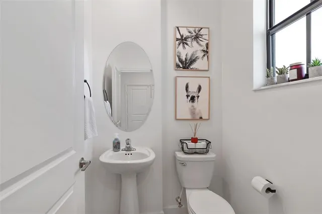 a bathroom with a toilet a sink and mirror