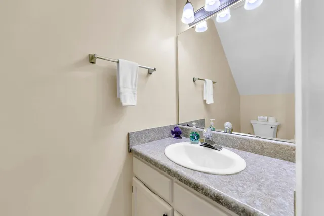 a bathroom with a granite countertop sink and a mirror
