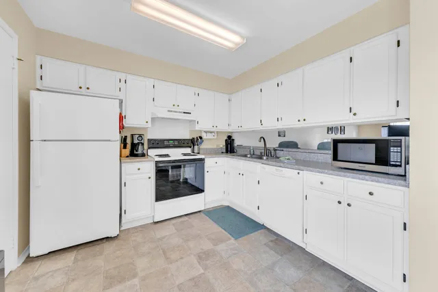 a kitchen with cabinets stainless steel appliances and sink