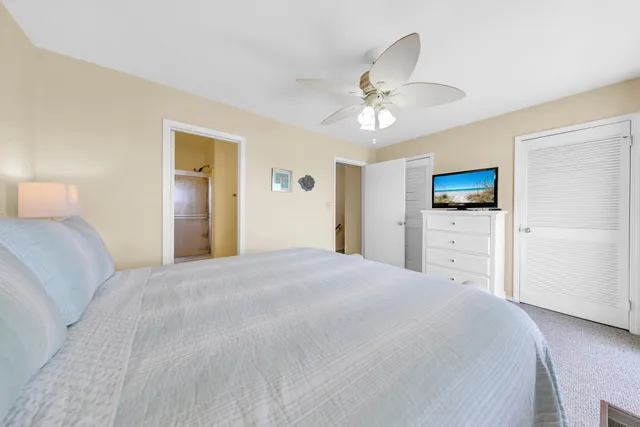 a spacious bedroom with a bed and a flat screen tv