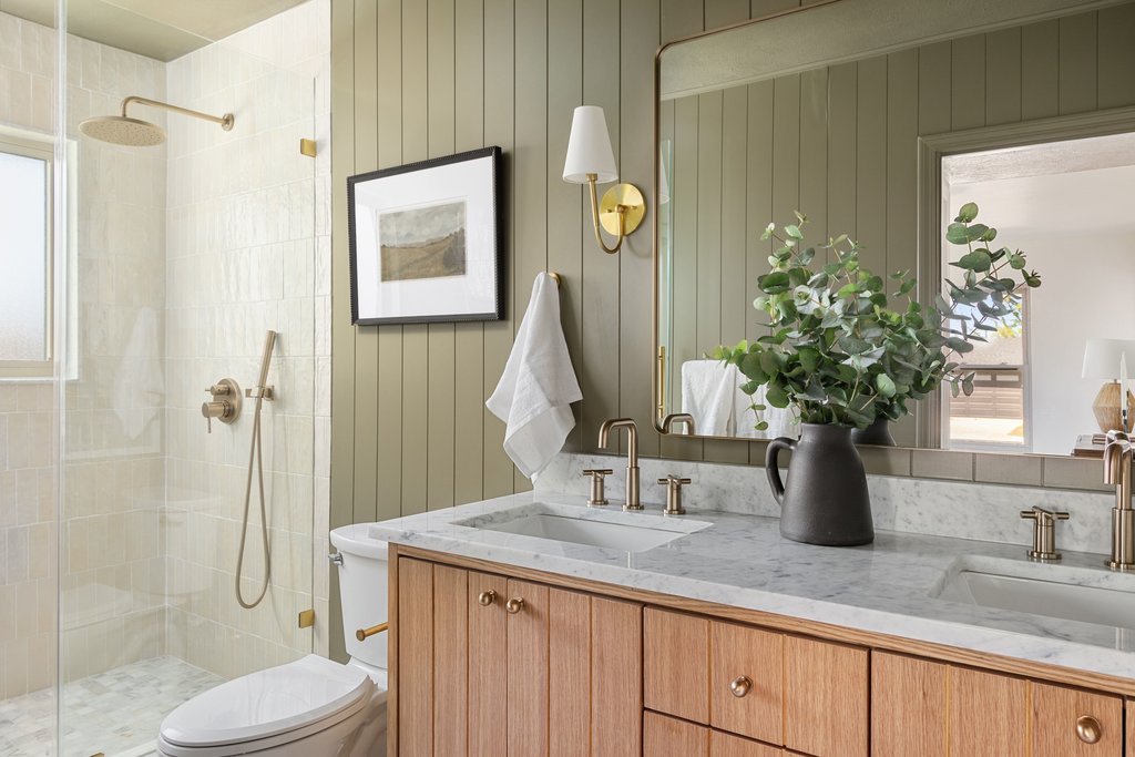 5213 Buffalo Pass Austin, TX 78745 - Photo 15 of 26 The primary spa-like bath has designer tile, dual vanities, storage, and warm wood tones.