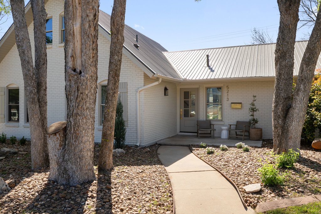 5213 Buffalo Pass Austin, TX 78745 - Photo 2 of 26 An inviting front entry with clean architectural lines, a covered fron porch and tree-lined sidewalk.